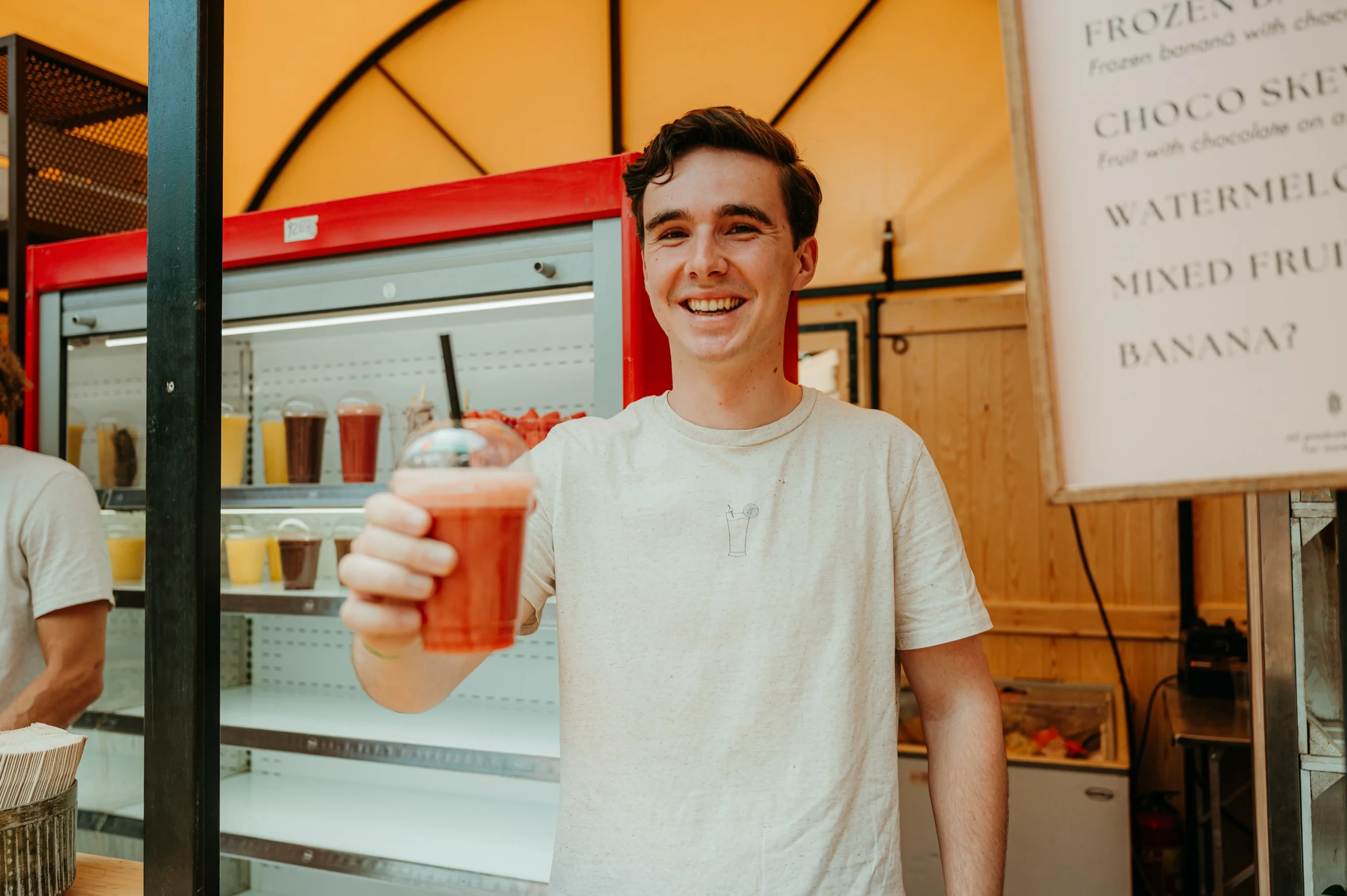 Gast met een vers sap voor het menubord van Bruis