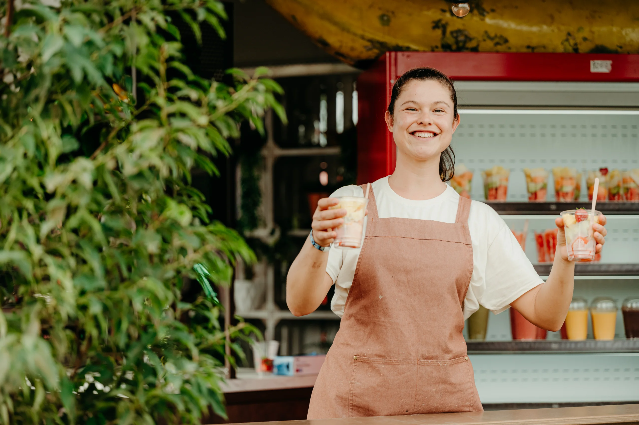 Medewerker overhandigt een verse smoothie aan een gast