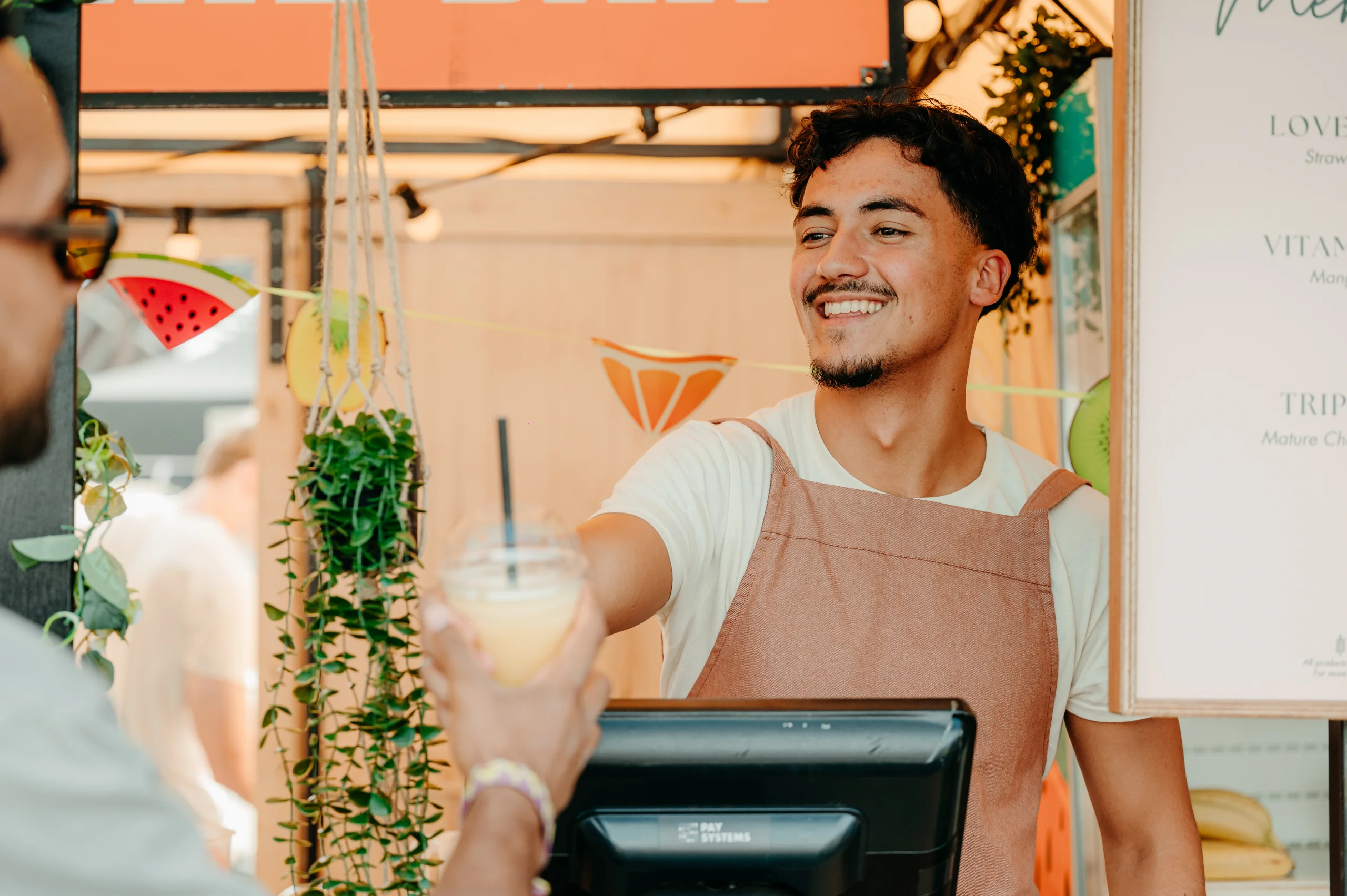 Medewerker overhandigt een verse smoothie aan een gast